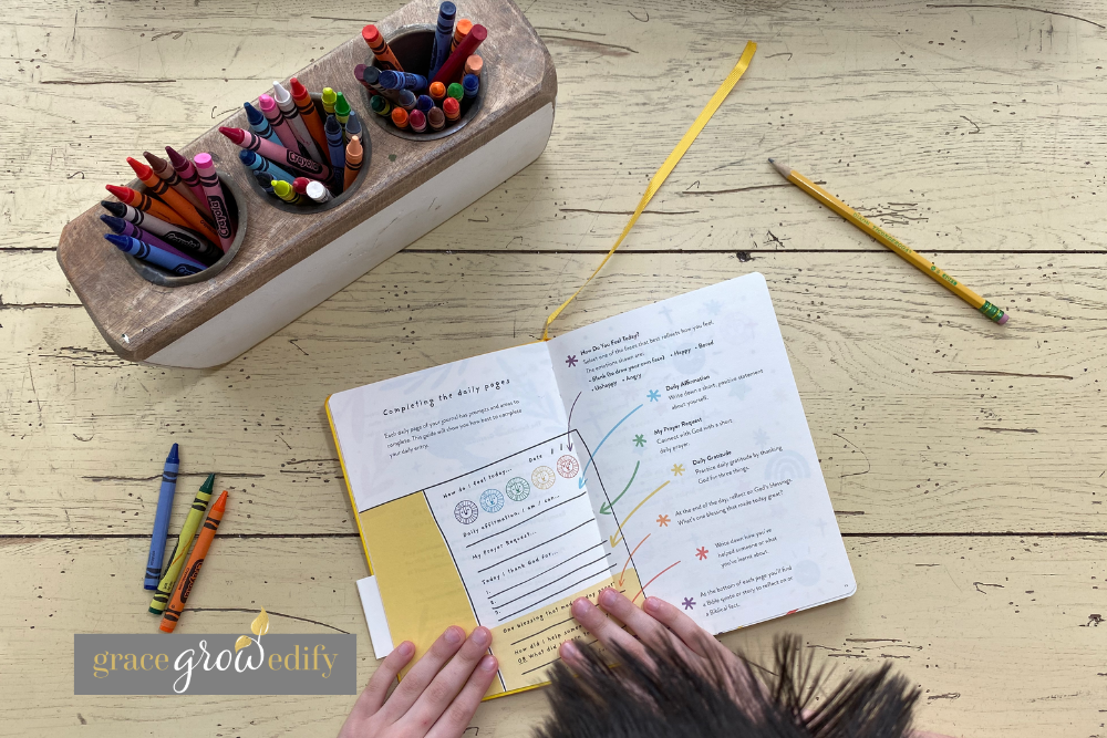 Child using a gratitude journal for kids, open to the instruction page, as part of a Christian homeschool journaling routine.
